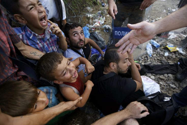 Syrian refugee children scream as they are siting in front of Macedonian riot police at the Greek-Macedonian border, near the village of Idomeni, August 21, 2015. Macedonian police fired tear gas and stun grenades to drive migrants and refugees back from its southern border from Greece on Friday but crowds continued to build up at a new bottleneck in an increasingly desperate flight to western Europe. At least 10 people were hurt in the brief flare-up, a day after the impoverished Balkan country declared a state of emergency on its border to halt a daily influx of up to 2,000 Syrians, Afghans, Iraqis and others heading north.   REUTERS/Yannis Behrakis