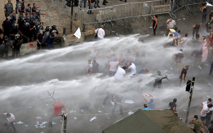 Lebanese protesters are sprayed with water during a protest against corruption and rubbish collection problems near the government palace in Beirut Lebanese protesters are sprayed with water during a protest against corruption and rubbish collection problems near the government palace in Beirut