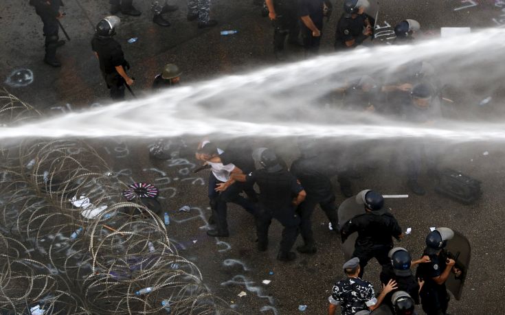Lebanese protesters are sprayed with water as police arrest a man during a protest against corruption and rubbish collection problems near the government palace in Beirut Lebanese protesters are sprayed with water as police arrest a man during a protest against corruption and rubbish collection problems near the government palace in Beirut