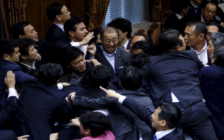 Lawmakers crowd around Konoike, chairman of the upper house special committee on security, during a vote at an upper house special committee session on security-related legislation at the parliament in Tokyo