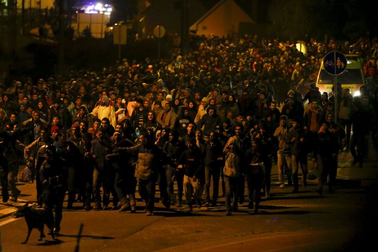 Migrants walk towards the Austrian border after arriving by train in the village of Sentilj, Slovenia, October 20, 2015. Slovenia will ask the European Union to send additional police forces to its border with Croatia to help it deal with thousands of migrants streaming into the tiny country on their way to Austria and beyond. Attempts by Slovenia to stem the flow of migrants since Hungary sealed its border with Croatia on Friday have triggered a knock-on effect through the Balkans, with thousands held up at border crossings. REUTERS/Leonhard Foeger      TPX IMAGES OF THE DAY