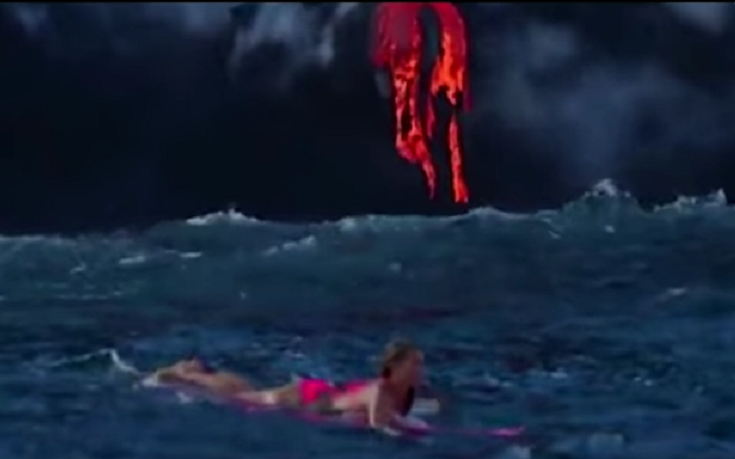 Γυναίκα κολυμπά σε θάλασσα που πέφτει λάβα από έκρηξη ηφαιστείου
