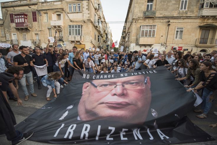 A banner with the photo of the Malta police commissioner Lawrence Cutajar is laid on the floor outside the Malta Police Headquarters during a spontaneous protest which followed a rally to honor anti-corruption reporter Daphne Caruana Galizia, killed by a car bomb on Oct. 16, in the capital city of Malta, Valletta, Sunday, Oct. 22, 2017. (AP Photo/Rene Rossignaud) A banner with the photo of the Malta police commissioner Lawrence Cutajar is laid on the floor outside the Malta Police Headquarters during a spontaneous protest which followed a rally to honor anti-corruption reporter Daphne Caruana Galizia, killed by a car bomb on Oct. 16, in the capital city of Malta, Valletta, Sunday, Oct. 22, 2017. (AP Photo/Rene Rossignaud)