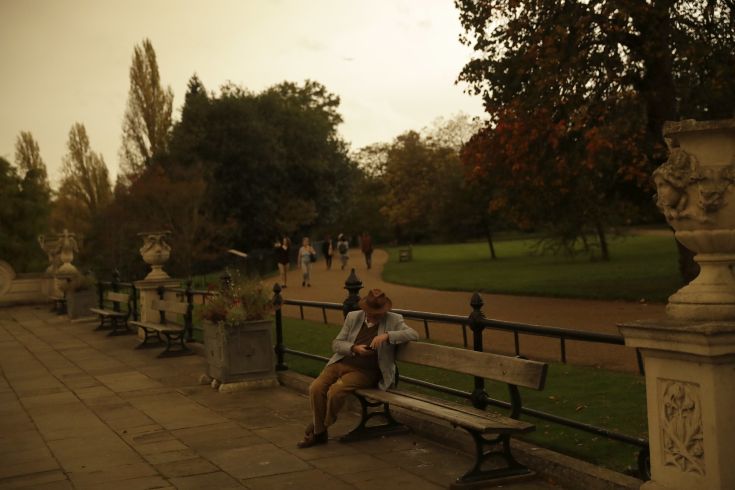 Hyde Park is bathed in a dull sepia light from the sky in London, Monday, Oct. 16, 2017. The unusual hue of the daylight sky was thought to be due to the remnants of Hurricane Orphelia dragging in tropical air and dust from the Sahara. (AP Photo/Matt Dunham)