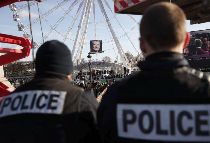 Police officers patrol during French rock star Johnny Hallyday's funeral ceremony in Paris, Saturday, Dec.9, 2017. France is bidding farewell to its biggest rock star, honoring Johnny Hallyday with an exceptional funeral procession down the Champs-Elysees, a presidential speech and a motorcycle parade, all under intense security. (AP Photo/Christophe Ena)