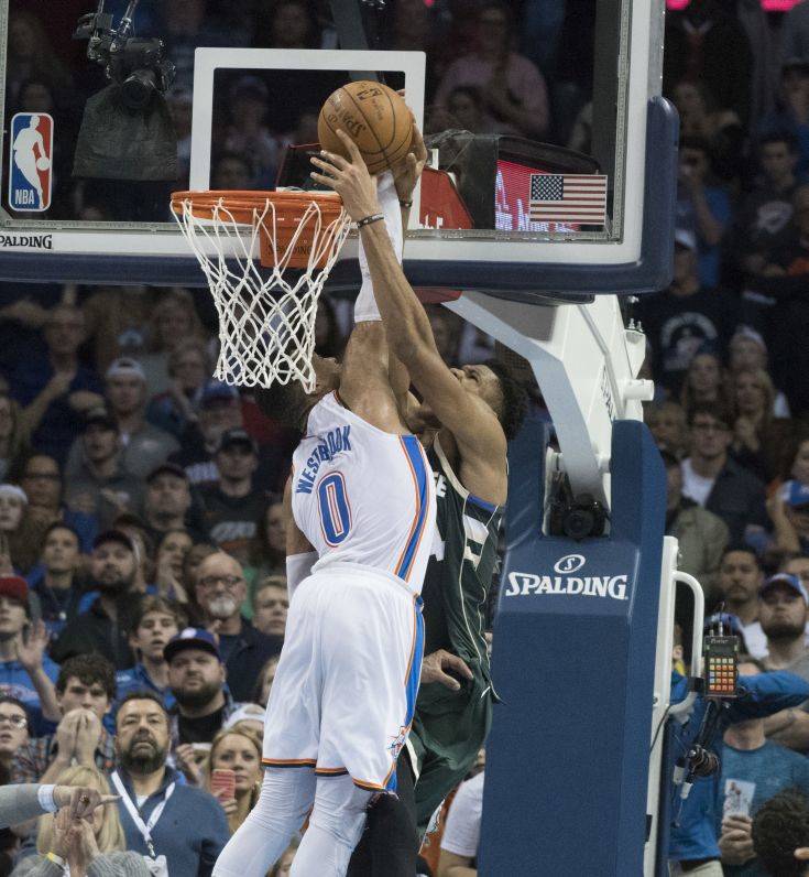 Milwaukee Bucks forward Giannis Antetokounmpo (34) shoots the winning goal as Oklahoma City Thunder guard Russell Westbrook (0) applies pressure during the second half of an NBA basketball game in Oklahoma City, Friday, Dec.29, 2017. The Bucks defeated the Thunder 97-95. (AP Photo/J Pat Carter)