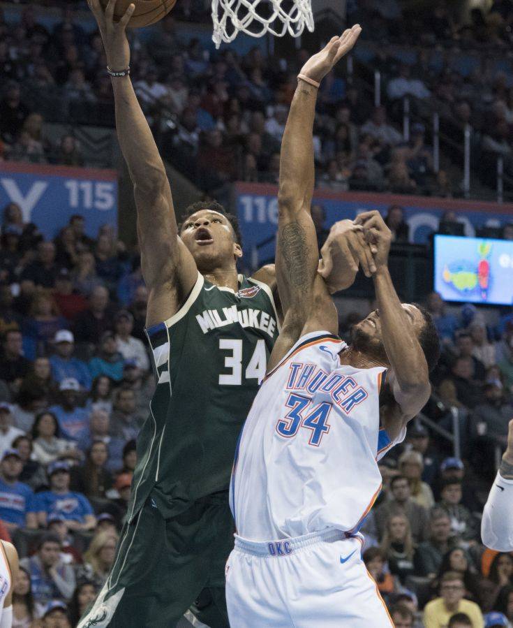 Milwaukee Bucks forward Giannis Antetokounmpo (34) and Oklahoma City Thunder forward Josh Huestis (34) battle for the ball during the first half of an NBA basketball game in Oklahoma City, Friday, Dec. 29, 2017. (AP Photo/J Pat Carter)