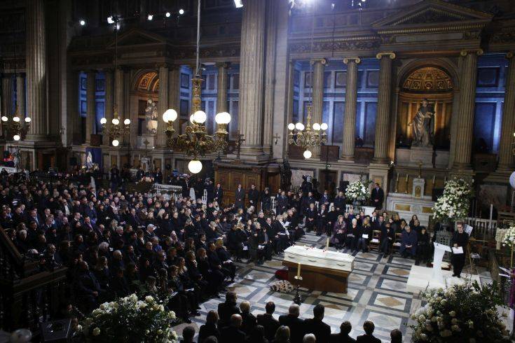Family members, officials and other mourners attend the funeral service of French rocker Johnny Hallyday at the Madeleine church, in Paris, France, Saturday, Dec. 9, 2017. France is bidding farewell to its biggest rock star, honoring Johnny Hallyday with an exceptional funeral procession down the Champs-Elysees, a presidential speech and a motorcycle parade — all under intense security. (AP Photo/Thibault Camus, Pool)