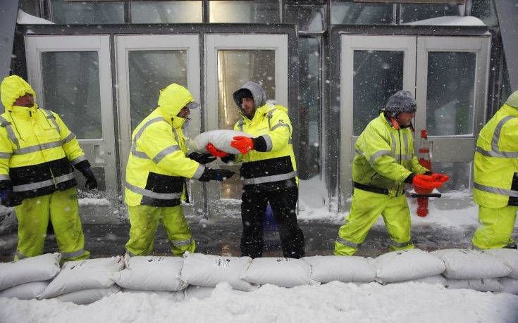 Workers place sand bags in front of Aquarium subway station to protect against flooding from Boston Harbor in Boston, Thursday, Jan. 4, 2018. A massive winter storm swept from the Carolinas to Maine on Thursday, dumping snow along the coast and bringing strong winds that will usher in possible record-breaking cold. (AP Photo/Michael Dwyer) Workers place sand bags in front of Aquarium subway station to protect against flooding from Boston Harbor in Boston, Thursday, Jan. 4, 2018. A massive winter storm swept from the Carolinas to Maine on Thursday, dumping snow along the coast and bringing strong winds that will usher in possible record-breaking cold. (AP Photo/Michael Dwyer)