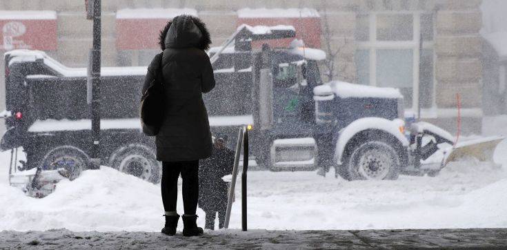 A woman waits for a ride as a snow plow passes in Boston, Thursday, Jan. 4, 2018. Forecasts for the Boston area call for about a foot of snow during the day and blizzard-like conditions. (AP Photo/Charles Krupa) A woman waits for a ride as a snow plow passes in Boston, Thursday, Jan. 4, 2018. Forecasts for the Boston area call for about a foot of snow during the day and blizzard-like conditions. (AP Photo/Charles Krupa)