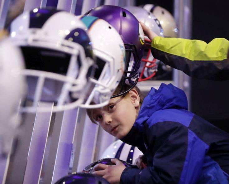 Beau Befort, 8, tries to slip his head into one of the helmets on display at the NFL Experience football fan attraction Friday, Feb. 2, 2018, in Minneapolis. The New England Patriots and the Philadelphia Eagles are scheduled to play in Super Bowl 52 Sunday, Feb. 4. (AP Photo/Mark Humphrey) Beau Befort, 8, tries to slip his head into one of the helmets on display at the NFL Experience football fan attraction Friday, Feb. 2, 2018, in Minneapolis. The New England Patriots and the Philadelphia Eagles are scheduled to play in Super Bowl 52 Sunday, Feb. 4. (AP Photo/Mark Humphrey)
