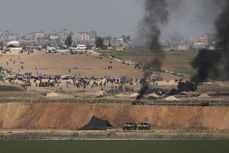 Israeli soldiers are seen as Palestinian demonstrators protest at the Israel Gaza border, Friday, April 6, 2018. Palestinians torched tires near Gaza's border with Israel on Friday, sending huge plumes of black smoke into the air and drawing tear gas and live fire from Israeli soldiers deployed on the other side of the border fence. (AP Photo/Tsafrir Abayov)