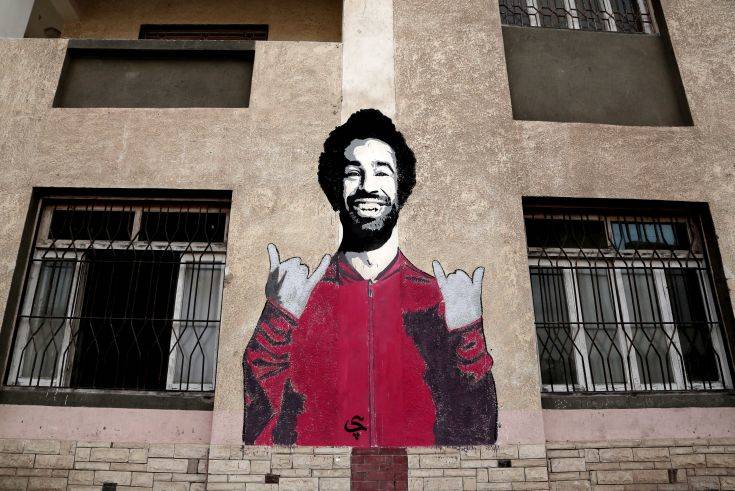 This May 2, 2018 photo, shows a wall mural of Mohamed Salah at a sports and youth center, in the Nile delta village of Nagrig, Egypt. Residents boast of how the Liverpool winger has poured millions of pounds into the village, with the beneficiaries’ list including a school, a mosque, a youth center and a dialysis machine at a nearby hospital. His success as a footballer in Europe’s most attractive league has inspired many parents in Nagrig to send their children to soccer academies in the hope that maybe one day they can emulate his success. (AP Photo/Nariman El-Mofty)