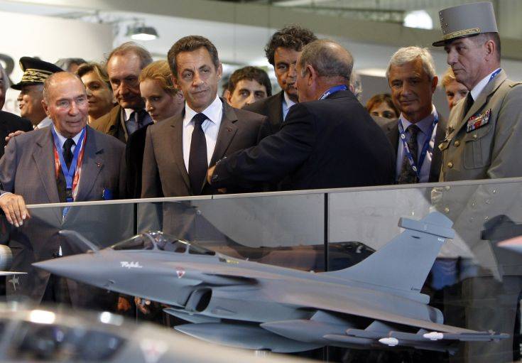 France's President Nicolas Sarkozy, second left, listens to a presentation stood next to a model of a Rafale jet Fighter as Dassault Group chairman Serge Dassault, left, looks on, during the opening of the Paris Air Show at Le Bourget, east of Paris, Monday June 20, 2011. (AP Photo/Francois Mori, Pool)
