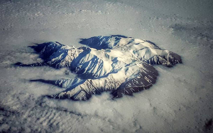 Εντυπωσιακή εικόνα με τον χιονισμένο Όλυμπο που ξεπροβάλλει μέσα από τα σύννεφα