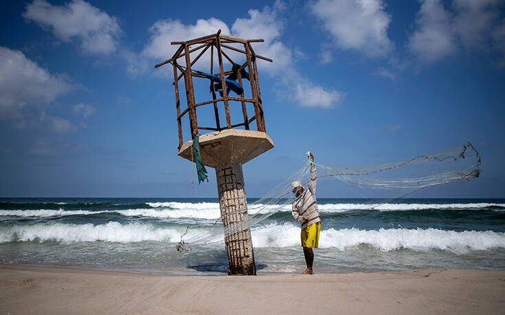 Палестинский рыбак чистит свою рыболовную сеть после решения Израиля закрыть рыболовную зону Газас на пляже в городе Газа во вторник, августа. 18 2020 Associated Press, лучшие фотографии недели