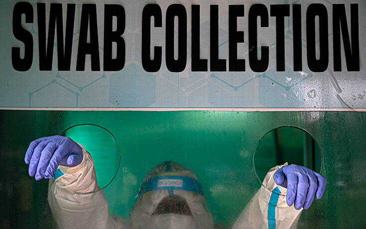 An Indian health worker waits to take a nasal swab sample to test for COVID 19 in a swab collection center in Gauhati India Monday Aug. 17 2020 Associated Press, οι καλυτερεΣ φωτογραφιεΣ τηΣ εβδομαδαΣ