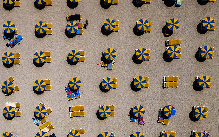 Купальщицы отдыхают под зонтиками на пляже на юго-западе острова Гран-Канария, Испания. Среда, август. 19 2020. Власти Испании объявили новые ограничения для предотвращения COVID 19 Associated Press, лучшие фото недели