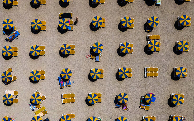 Bathers relax under umbrellas on a beach in southwest Gran Canaria island Spain Wednesday Aug. 19 2020. Spanish authorities have announced new restrictions to prevent COVID 19 Associated Press, οι καλυτερεΣ φωτογραφιεΣ τηΣ εβδομαδαΣ