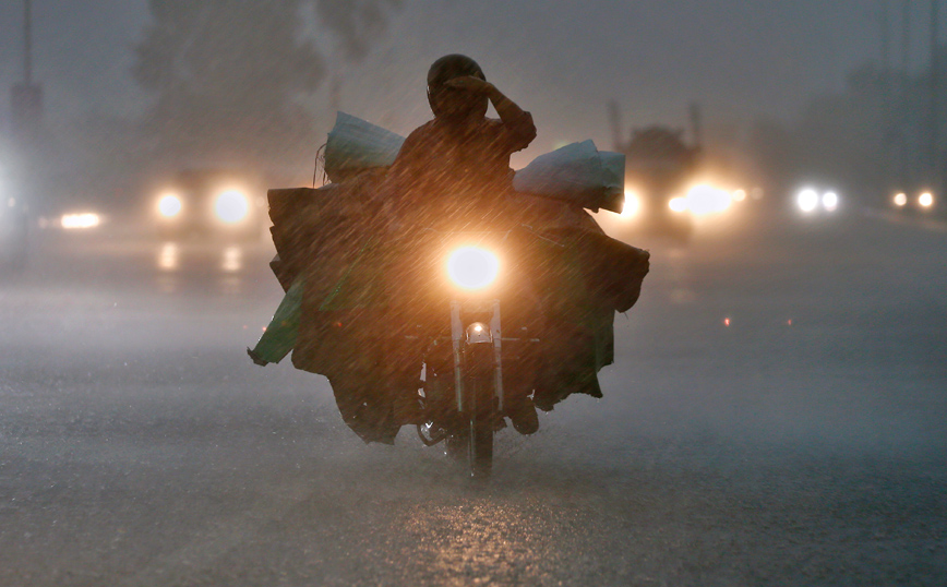 Οδηγός μηχανής μέσα στη βροχή Οδηγός μηχανής μέσα στη βροχή