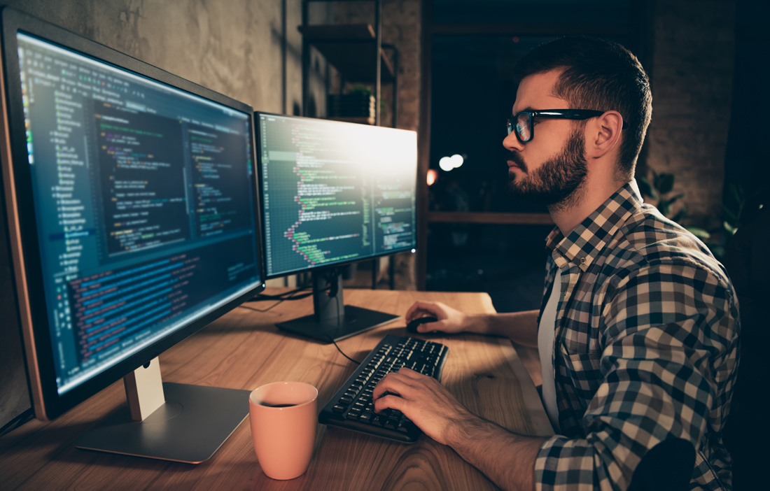 Εργαζόμενος μπροστά σε 2 λάπτοπ Εργαζόμενος μπροστά σε 2 λάπτοπ