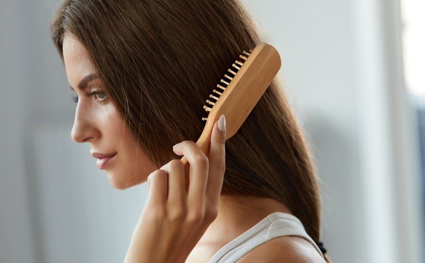 Γυναίκα βουρτσίζει τα μαλλιά της