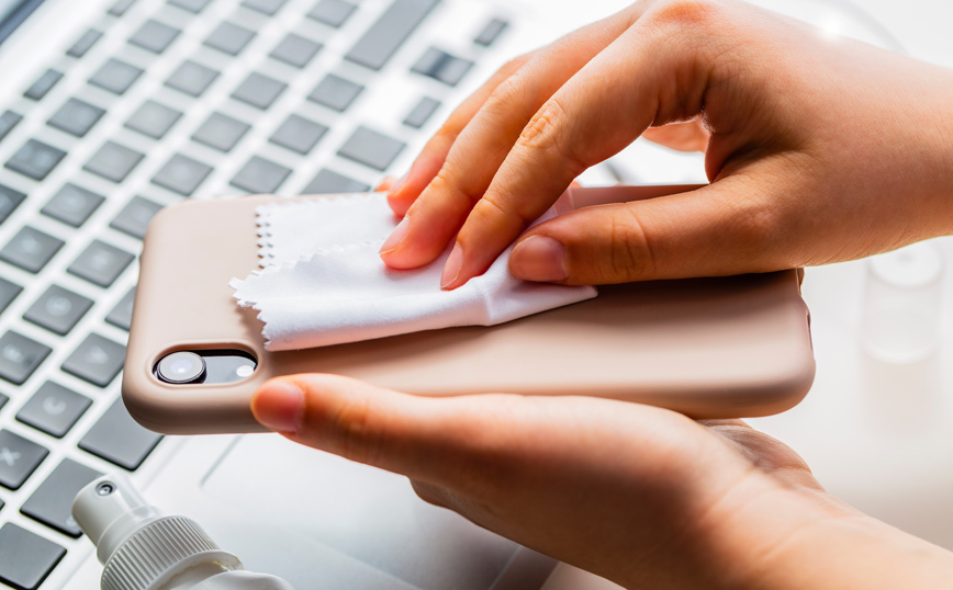 Γυναίκα καθαρίζει το κινητό της Γυναίκα καθαρίζει το κινητό της