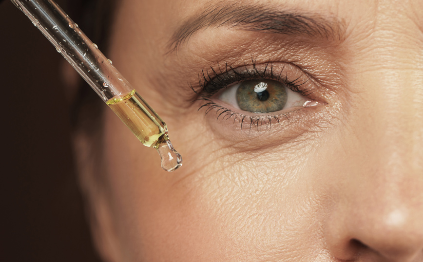 Γυναίκα περιποιείται το πρόσωπό της με αντιγηραντικό προϊόν