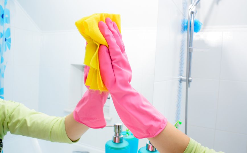 Γυναίκα καθαρίζει καθρέφτη μπάνιου Γυναίκα καθαρίζει καθρέφτη μπάνιου