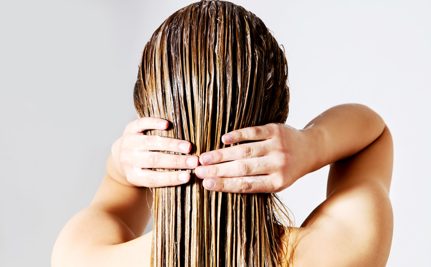 Γυναίκα περιποιείται τα μαλλιά της Γυναίκα περιποιείται τα μαλλιά της