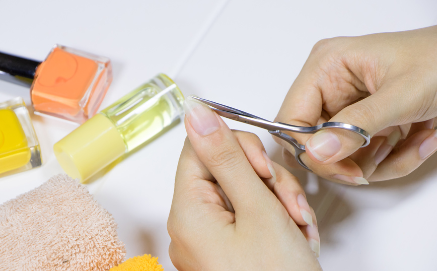 Γυναίκα κόβει τα νύχια της με ψαλιδάκι Γυναίκα κόβει τα νύχια της με ψαλιδάκι