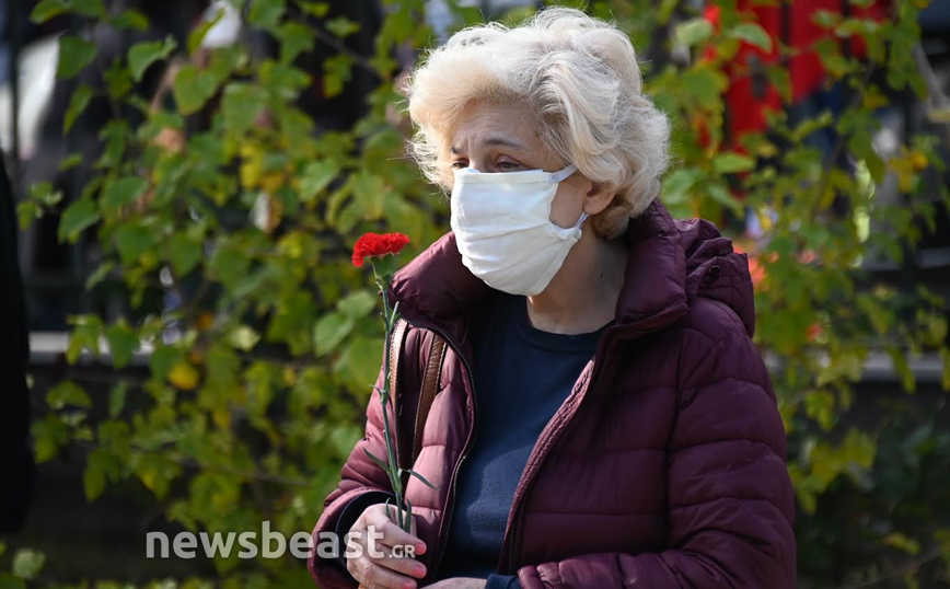 Γυναίκα κρατάει γαρύφαλλο στο Πολυτεχνείο