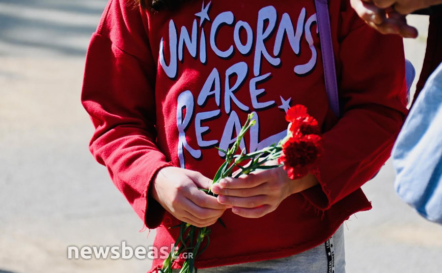 Κρατάει γαρύφαλλο 