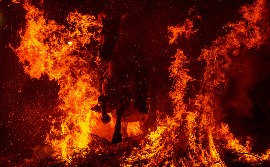 Άλογο και αναβάτης παιρνούν μέσα από τις φλόγες Άλογο και αναβάτης παιρνούν μέσα από τις φλόγες
