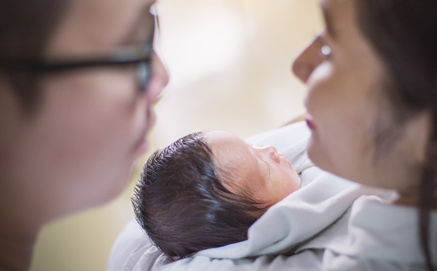 Νεογέννητο στα χέρια γυναίκας Νεογέννητο στα χέρια γυναίκας