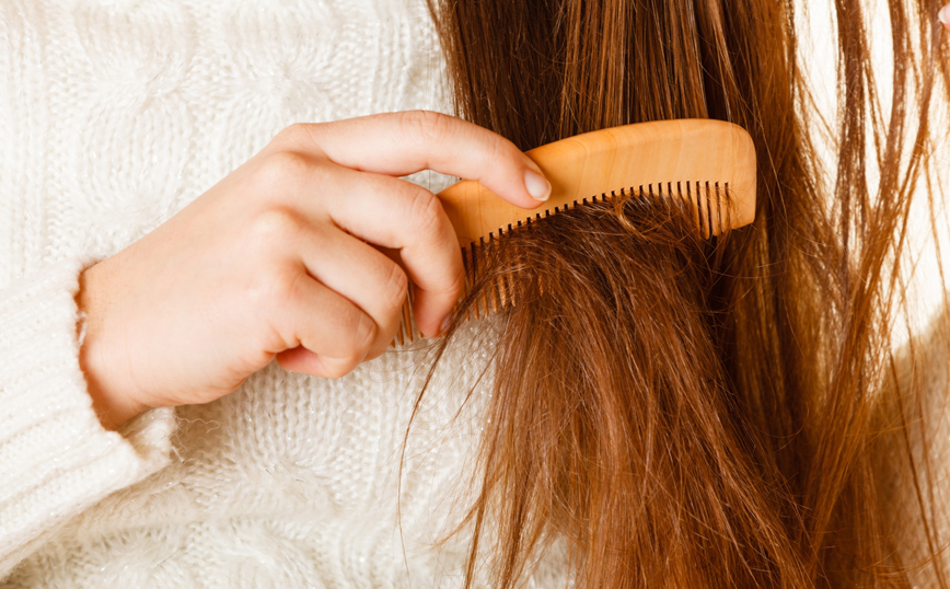 Γυναίκα χτενίζει τα μαλλιά της Γυναίκα χτενίζει τα μαλλιά της