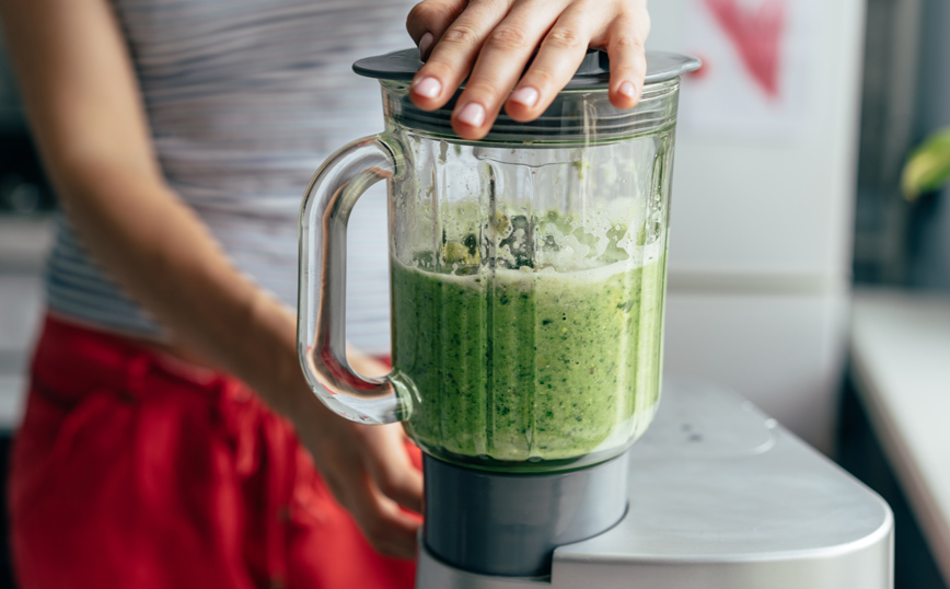 Γυναίκα φτιάχνει πράσινο smoothie
