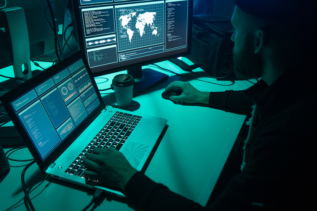 Ένας χάκερ μπροστά σε οθόνες Ένας χάκερ μπροστά σε οθόνες