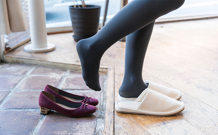 Γυναίκα βγάζει παούτσια και φορά παντόφλες Γυναίκα βγάζει παούτσια και φορά παντόφλες