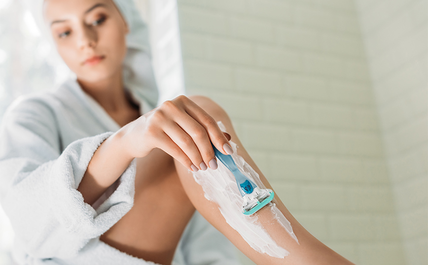 Γυναίκα ξυρίζει το πόδι της Γυναίκα ξυρίζει το πόδι της