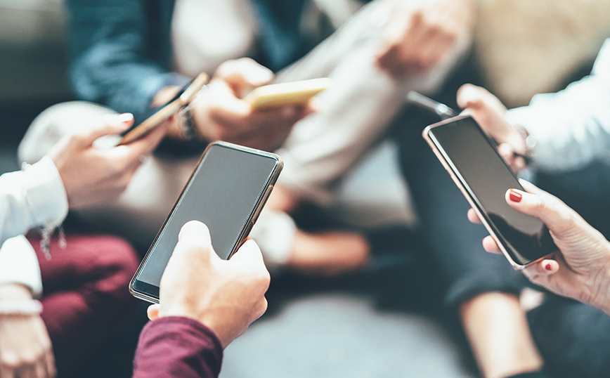 Νέοι με κινητά στα χέρια Νέοι με κινητά στα χέρια