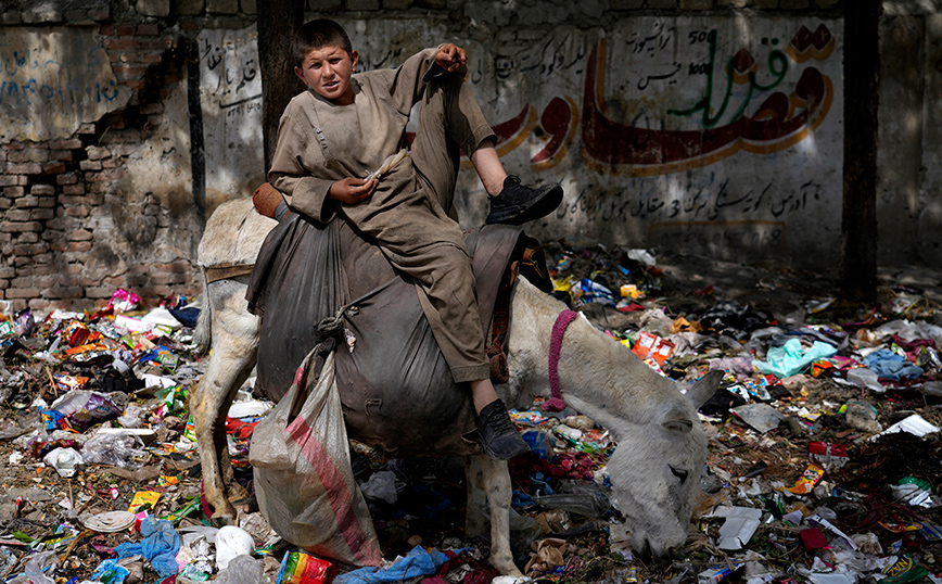 Παιδί παίζει μέσα στα σκουπίδια Παιδί παίζει μέσα στα σκουπίδια