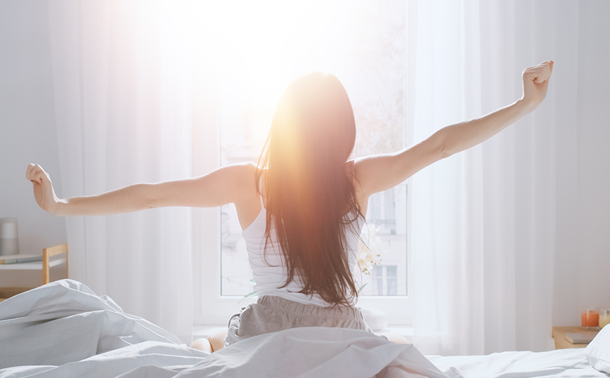 Γυναίκα που μόλις ξύπνησε τεντώνεται Γυναίκα που μόλις ξύπνησε τεντώνεται