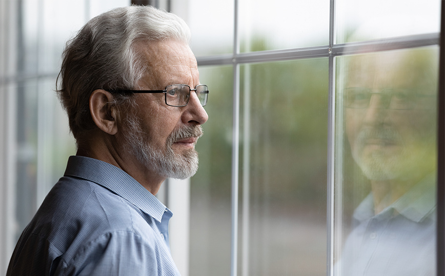 Ηλικιωμένος άντρας κοιτάει έξω από το παράθυρο Ηλικιωμένος άντρας κοιτάει έξω από το παράθυρο