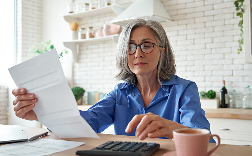 Ηλικιωμένη γυναίκα υπολογίζει λογαριασμούς Ηλικιωμένη γυναίκα υπολογίζει λογαριασμούς