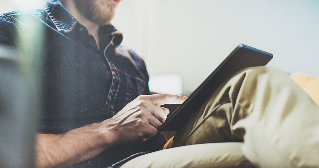 Άντρας κοιτάει στο τάμπλετ