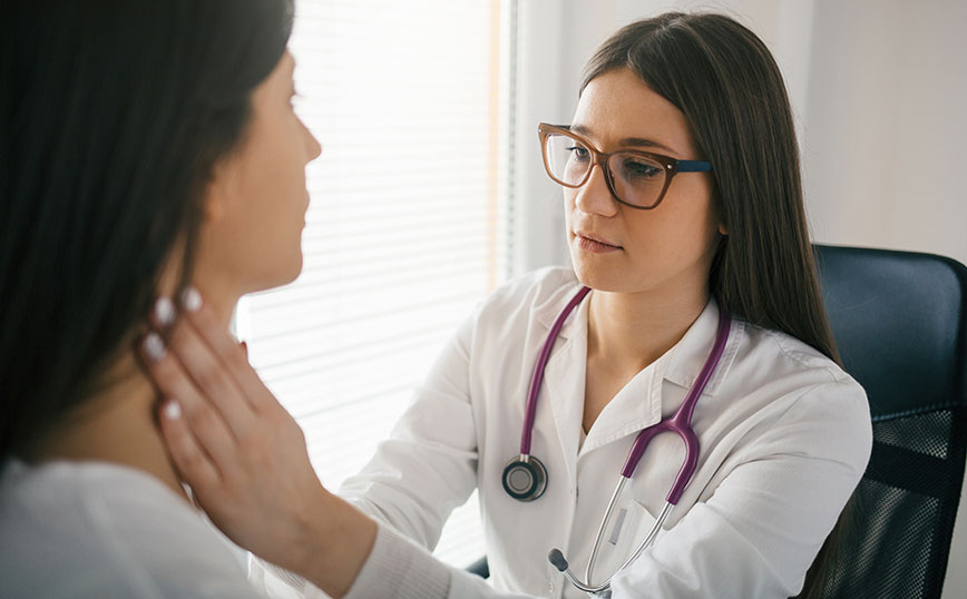 Γιατρός ψηλαφίζει λαιμό ασθενούς Γιατρός ψηλαφίζει λαιμό ασθενούς