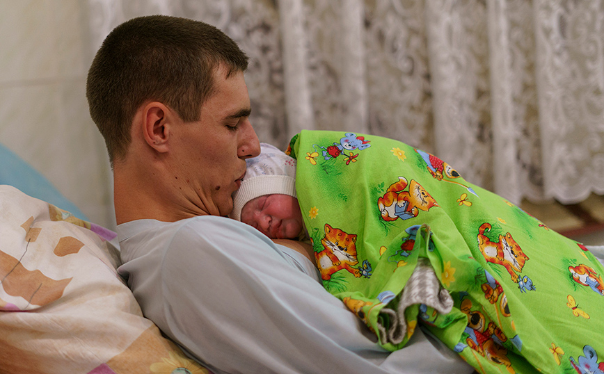 Άντρας αγκαλιάζει το μωρό του Άντρας αγκαλιάζει το μωρό του