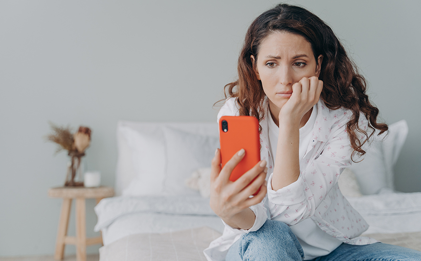 Γυναίκα που κοιτάει στο κινητό προβληματισμένη Γυναίκα που κοιτάει στο κινητό προβληματισμένη