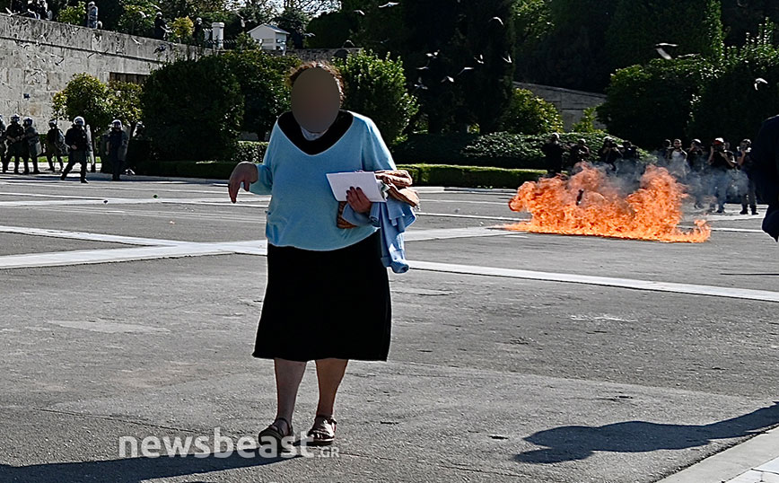 Η κυρία στο Σύνταγμα που κάνει τη βόλτα της χωρίς να δίνει καμία σημασία στις μολότοφ και τα χημικά